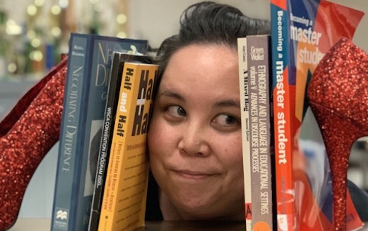 Nikki smiling in between books