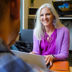 Karen Rubin with computer and smiling while advising